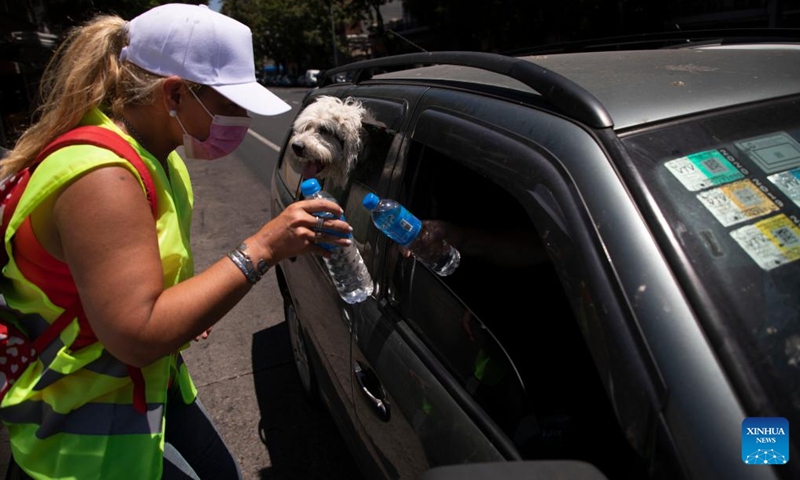 A worker of the government distributes free bottled water to residents in Buenos Aires, Argentina, Jan. 13, 2022. A heat wave swept across most parts of Argentina recently.Photo:Xinhua