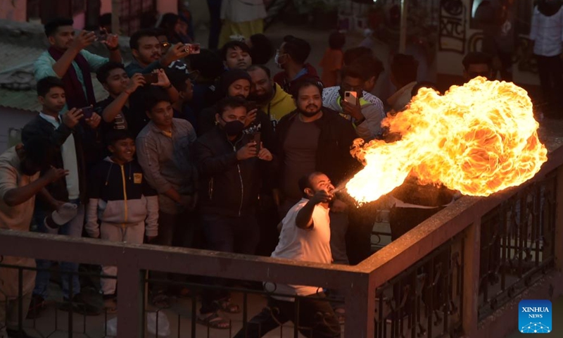 Pada 14 Januari 2022, seorang pria menghembuskan api selama festival sakramen di Dhaka, ibu kota Bangladesh.  Orang-orang di Dhaka merayakan festival kalender Sakramen (14 atau 15 Januari dalam kalender Gregorian).  foto: Xinhua