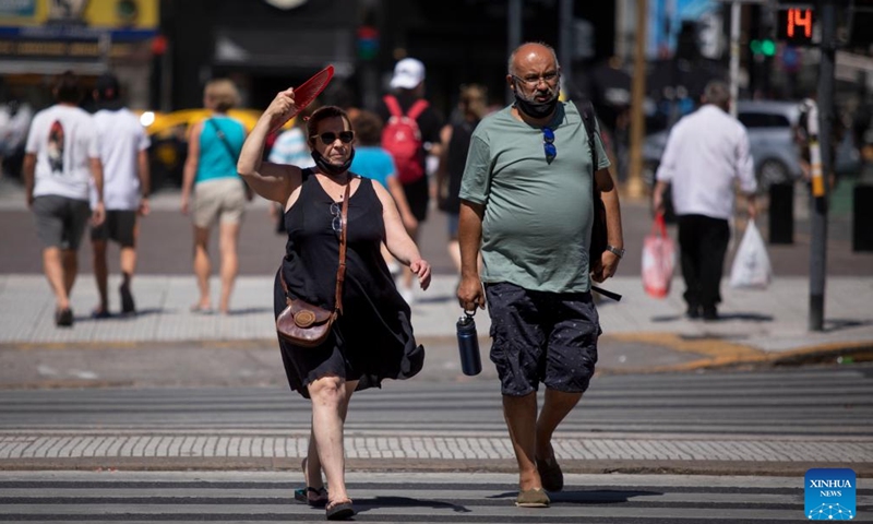 A woman holds the fan above her head to block away the sunlight in Buenos Aires, Argentina, Jan. 13, 2022. A heat wave swept across most parts of Argentina recently.Photo:Xinhua