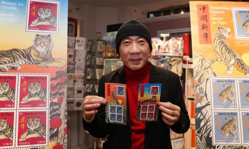Paris-based Chinese artist Chen Jianghong displays the Year of Tiger commemorative stamps designed by him during an issuing ceremony in Paris, France, Jan. 22, 2022. French postal service company La Poste issued two Year of Tiger stamps in a ceremony here on Saturday to celebrate the Chinese Lunar New Year. This year's stamps are designed by Paris-based Chinese artist Chen Jianghong. (Xinhua)