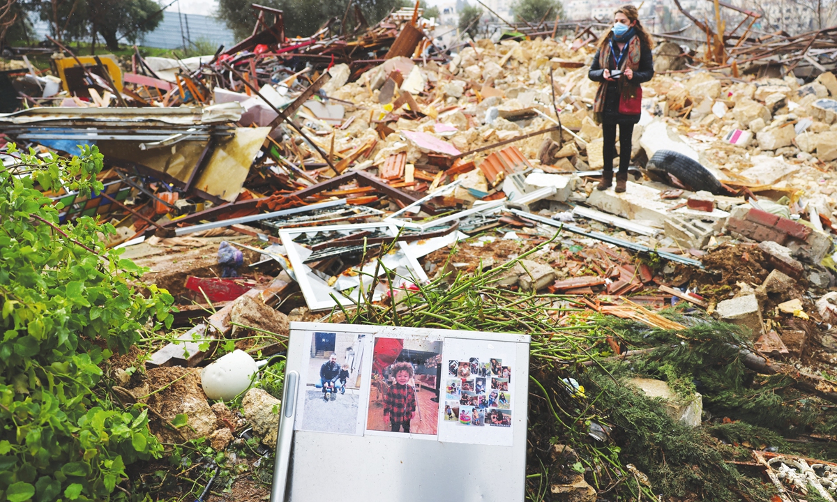 Family pictures are left on the ruins of the Palestinian Salhiya family's house, demolished by Israeli forces, in Sheik Jarrah neighborhood on January 19, 2022. Israeli officers went to the home of the Salhiya family, threatened with eviction since 2017, early Wednesday morning. Photo: AFP