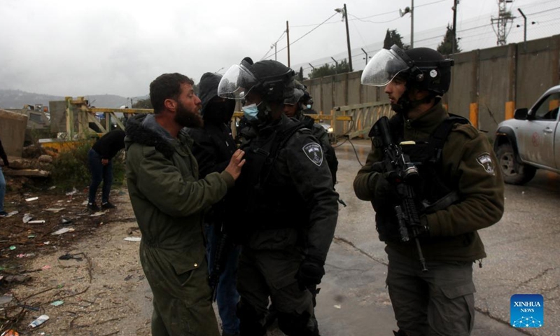 Palestinians argue with members of Israeli border police near the gate of the Shavei Shomron Israeli checkpoint, north of the West Bank city of Nablus, on Jan. 16, 2022. The Israeli army closed the street three weeks ago after an Israeli settler was killed and two others were wounded last month.Photo:Xinhua