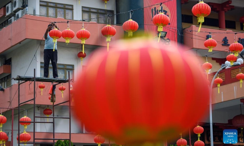A man hangs lanterns for the upcoming Spring Festival, or the Chinese Lunar New Year, in Klang of Selangor states, Malaysia, Jan. 16, 2022.Photo:Xinhua