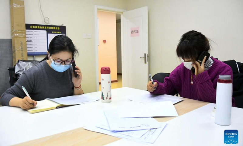Community workers checks information of residents at a residential compound in Haidian District of Beijing, capital of China, Jan. 16, 2022.Photo:Xinhua