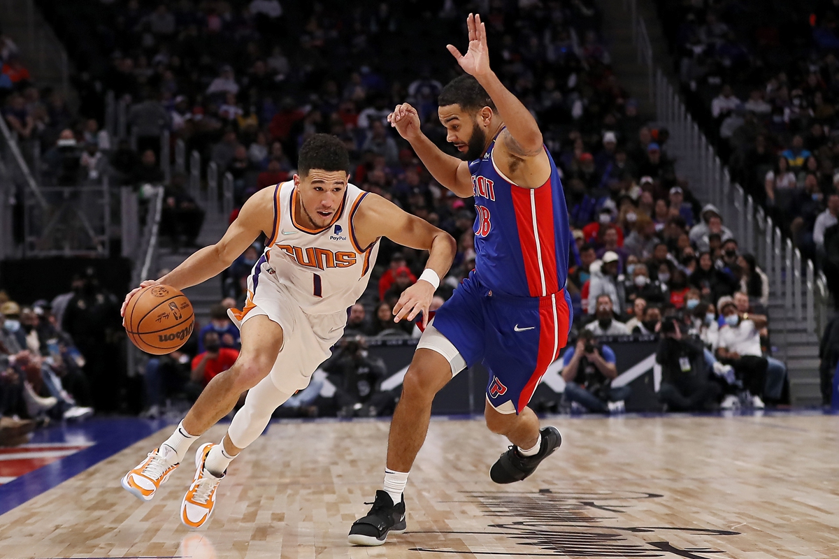 Devin Booker (left) of the Phoenix Suns drives the ball against Cory Joseph of the Detroit Pistons on January 16, 2022 in Detroit, Michigan. Photo: VCG