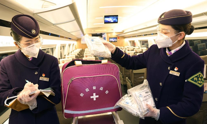 Crew members prepare epidemic prevention kits on train G1724 in east China's Shanghai, Jan. 16, 2022.Photo:Xinhua