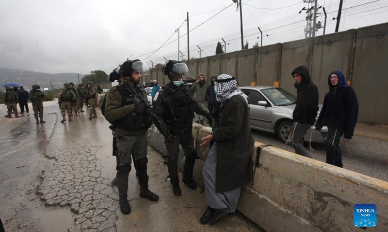 Palestinians argue with members of Israeli border police near the gate of the Shavei Shomron Israeli checkpoint, north of the West Bank city of Nablus, on Jan. 16, 2022. The Israeli army closed the street three weeks ago after an Israeli settler was killed and two others were wounded last month.Photo:Xinhua