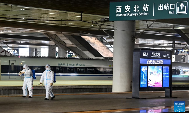 Staff members spray disinfectants on the platform of Xi'an North Railway Station in Xi'an, northwest China's Shaanxi Province, Jan. 16, 2022.Photo:Xinhua