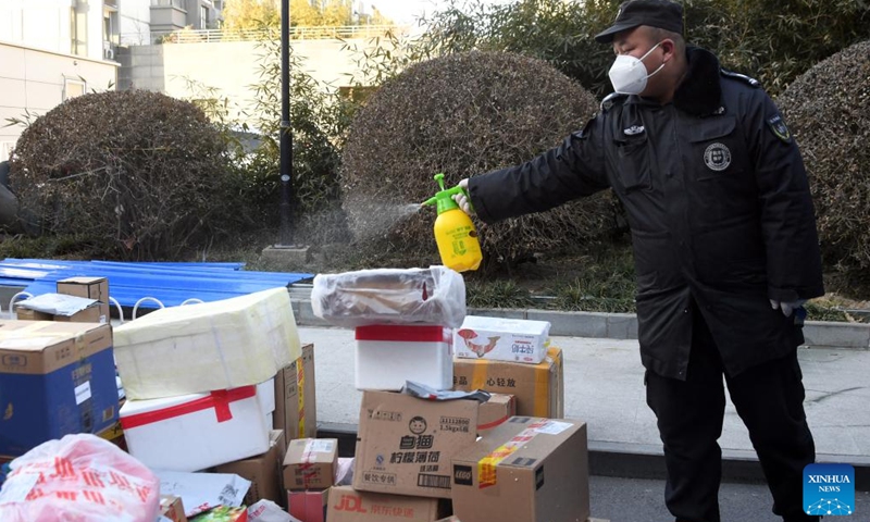 A staff member disinfects parcels to be delivered to residents at a residential area in Haidian District of Beijing, capital of China, Jan. 16, 2022.Photo:Xinhua