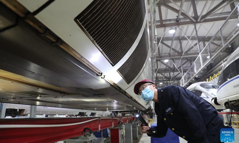 A staff member checks a bullet train at a maintenance base of Lanzhou West bullet train service station in Lanzhou, northwest China's Gansu Province, Jan. 16, 2022. Staff members from Lanzhou West bullet train service station of Lanzhou section of China Railway Lanzhou Group Co., Ltd. carried out maintenance work for trains to prepare for the country's annual Spring Festival travel rush.(Photo: Xinhua)