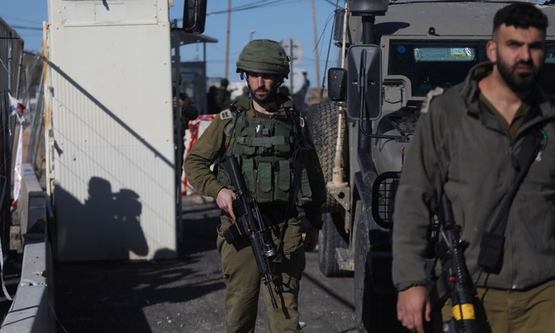 Israeli soldiers are seen at the scene where a knife-wielding Palestinian man was shot dead at the Gush Etzion Junction north of the West Bank city of Hebron, on Jan. 17, 2022.(Photo: Xinhua)