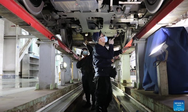 Staff members check a bullet train at a maintenance base of Lanzhou West bullet train service station in Lanzhou, northwest China's Gansu Province, Jan. 16, 2022. Staff members from Lanzhou West bullet train service station of Lanzhou section of China Railway Lanzhou Group Co., Ltd. carried out maintenance work for trains to prepare for the country's annual Spring Festival travel rush.(Photo: Xinhua)