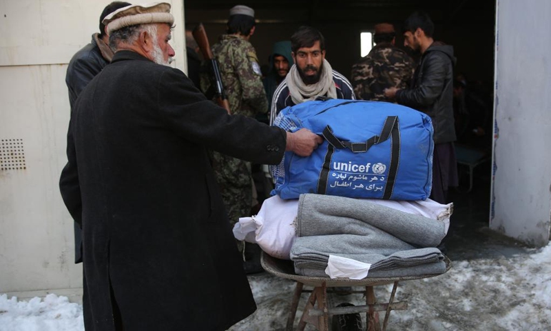 People receive donated relief assistance in Kabul, capital of Afghanistan, Jan. 18, 2022. About 1,000 displaced and needy Afghan families received relief assistance in the capital Kabul on Tuesday as the Taliban-led caretaker government and aid agencies redoubled efforts to help destitute families in winter, authorities said on Tuesday.(Photo: Xinhua)