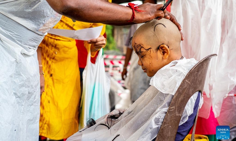 A child gets his hair cut in a barber shop as Hindu devotees celebrate the Thaipusam festival at Batu Caves on the outskirts of Kuala Lumpur, Malaysia, Jan. 18, 2022.(Photo: Xinhua)