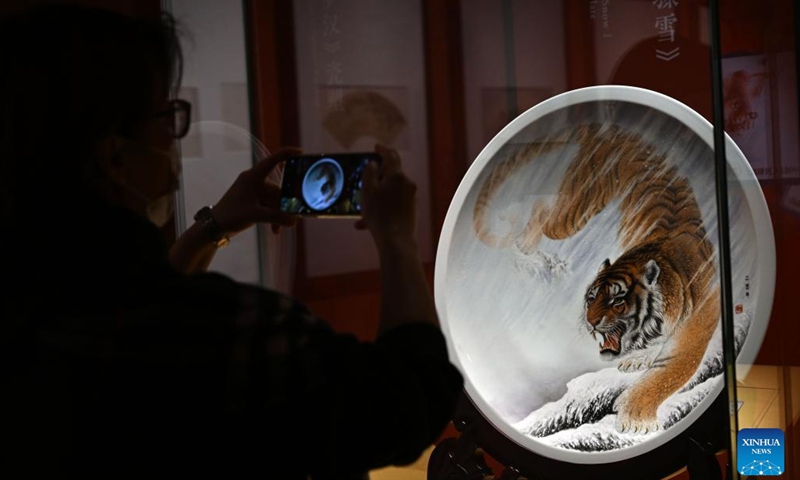 A visitor takes pictures of an artifact displayed during the tiger-themed exhibition at the National Museum of China in Beijing, capital of China, Jan. 19, 2022. As the Year of Tiger approaches, The Tiger as Talisman: 2022 Chinese New Year Exhibition, with a selection of artworks showcasing tiger in Chinese culture, opened to the public here on Wednesday.(Photo: Xinhua)