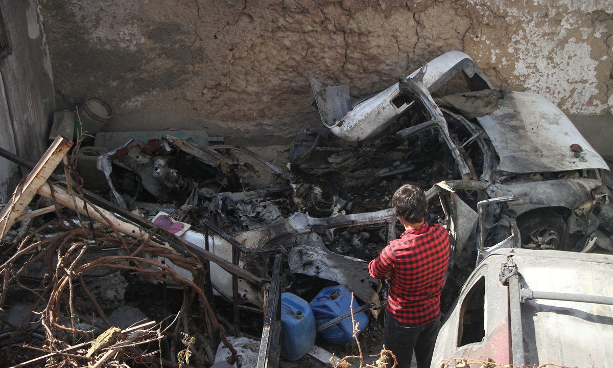 A local resident stands next to the wreckage of a car in a neighborhood hit by a US airstrike in Kabul, Afghanistan on September 2, 2021. Photo: Xinhua