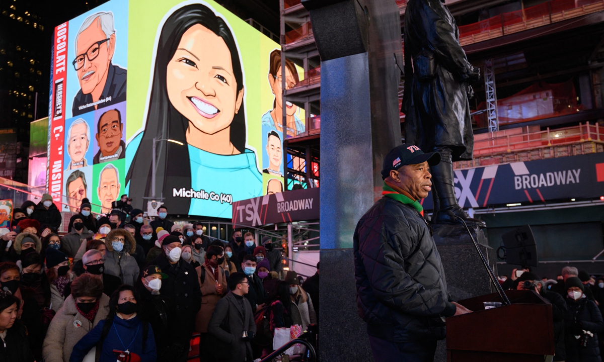 A vigil held in honour of Michelle Go, whose image is displayed on a near by building (top, rear),in Times Square, New York on Tuesday. Photo: AFP