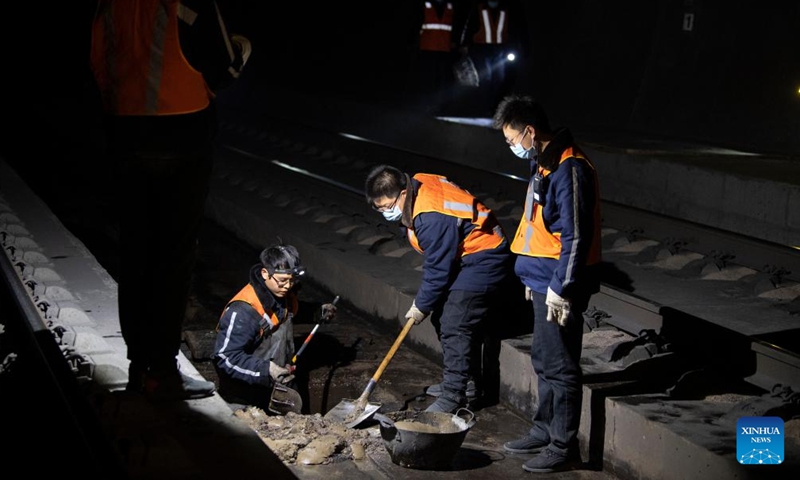 Bridge and tunnel workers dredge the sewerage system of the Wubao Tunnel on the railway linking Taiyuan of north China's Shanxi Province and Zhongwei of northwest China's Ningxia Hui Autonomous Region, Jan. 20, 2022.Photo:Xinhua