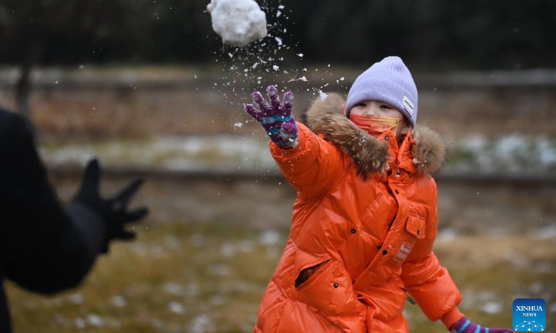 A child plays with snow on the street in Xi'an, northwest China's Shaanxi Province, Jan. 23, 2022.Photo:Xinhua
