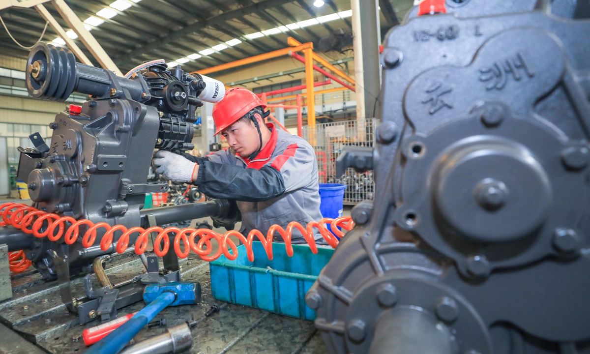 A worker equips a smart combine harvester in Huzhou, East China's Zhejiang Province on January 24, 2022. China will see 70 percent of its major manufacturing firms basically digitalized and networked by 2025, according to a development plan on smart manufacturing. Photo: cnsphoto