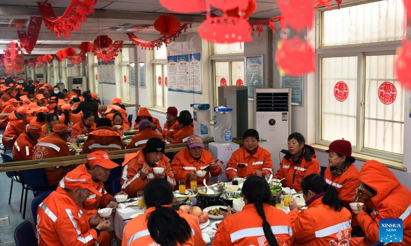 Sanitation workers have a reunion dinner at Gongwan Road sanitation station in Luyang District, Hefei, east China's Anhui Province, Jan. 24, 2022. Local urban management bureau on Monday offered a reunion dinner for more than 40 sanitation workers who choose to stay put at their positions during the upcoming Spring Festival.(Photo: Xinhua)