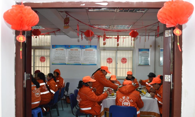 Sanitation workers have a reunion dinner at Gongwan Road sanitation station in Luyang District, Hefei, east China's Anhui Province, Jan. 24, 2022. Local urban management bureau on Monday offered a reunion dinner for more than 40 sanitation workers who choose to stay put at their positions during the upcoming Spring Festival.(Photo: Xinhua)