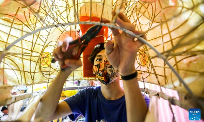 A member of a costume workshop works on a lion head costume in Manila, the Philippines, Jan. 24, 2022. Although most of performances for the upcoming Chinese lunar New Year celebrations are canceled in Manila due to epidemic prevention and control measures, local dragon and lion costume workshops still work on creations for customers who are ready to buy or rent the costumes to display. (Photo: Xinhua)