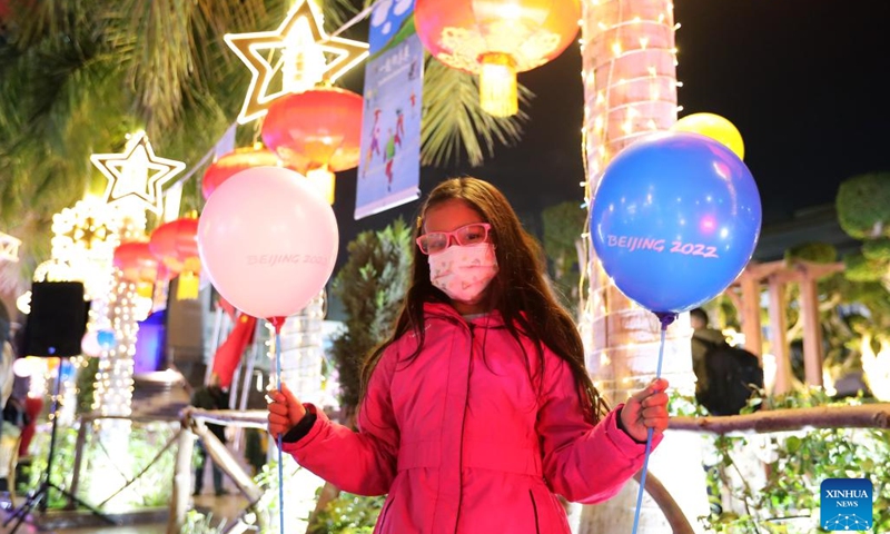 A child poses for pictures during a light show in Cairo, Egypt, on Jan. 24, 2022. A light show was held at the Cairo Tower for the upcoming Beijing 2022 Winter Olympics.(Photo: Xinhua)