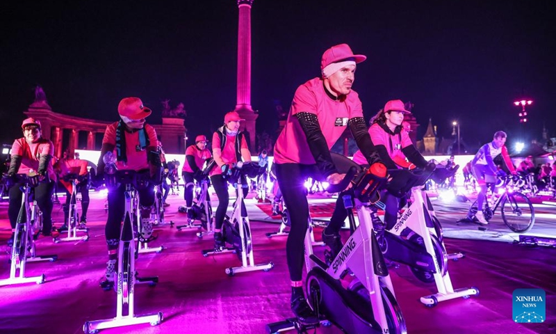 Participants ride spinning machines during a promotional event of Giro d'Italia 2022 bike race held on Heroes Square in Budapest, Hungary on Jan. 26, 2022. The race will start on May 6. (Photo by Csaba Domotor/Xinhua)