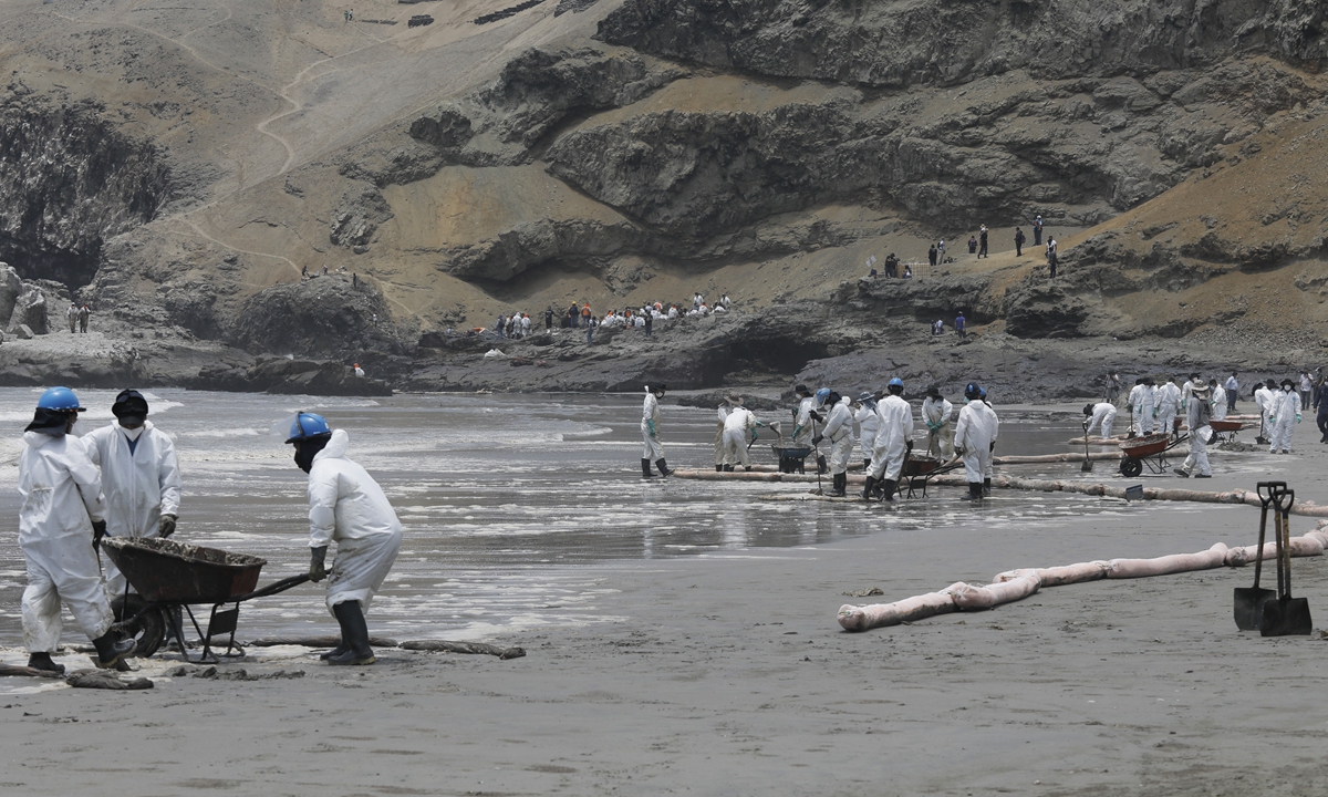 Cleaning teams work to remove oil along the shore after an oil spill in the Ventanilla Sea in the province of Callao stained the beaches of the district area in Lima, Peru on January 20, 2022.Photo: AFP