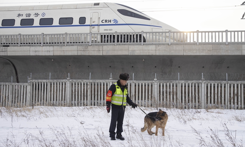 Patrollman Yu Zhenlong and patrol dog Hu Zi work along the railway near Daqing West Railway Station in Daqing, northeast China's Heilongjiang Province, Jan. 24, 2022. Hu Zi, a 14-year-old patrol dog working for the Harbin-Qiqihar railway, the country's northernmost high speed railway, will retire after its last mission during this year's Spring Festival travel rush.Hu Zi has patrolled along the railway at an accumulative distance of 80,000 km through its 7 years of service.(Photo: Xinhua)