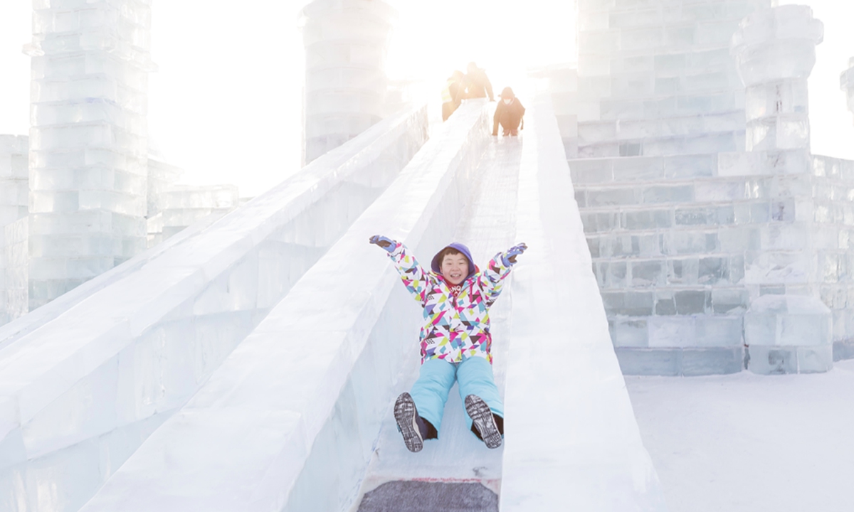A child plays ice slide at the Harbin Ice and Snow World theme park in Harbin, Northeast China's Heilongjiang Province.Photo: VCG