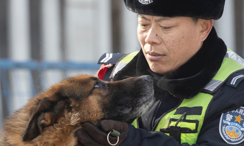 Patrollman Wang Hongbin and patrol dog Hu Zi take a rest during their patrol along the railway in Daqing, northeast China's Heilongjiang Province, Jan. 24, 2022. Hu Zi, a 14-year-old patrol dog working for the Harbin-Qiqihar railway, the country's northernmost high speed railway, will retire after its last mission during this year's Spring Festival travel rush. Hu Zi has patrolled along the railway at an accumulative distance of 80,000 km through its 7 years of service.(Photo: Xinhua)