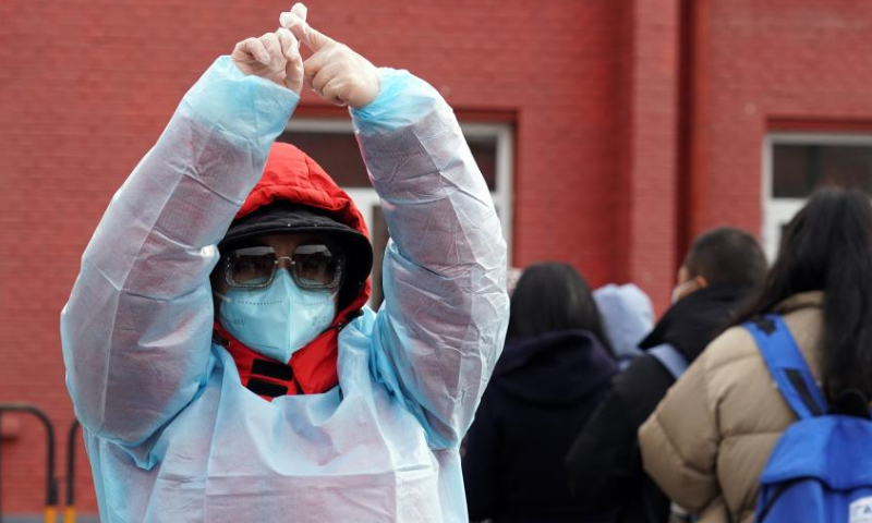 A staff member gestures to maintain order at a COVID-19 testing site in Xicheng District in Beijing, capital of China, Jan. 26, 2022. (Xinhua)