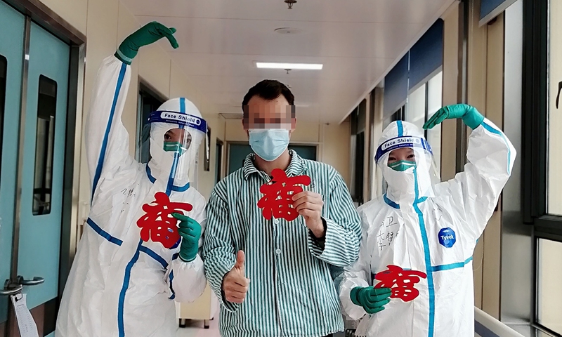A French COVID-19 patient poses with nurses showing the paper-cutting he made before he was discharged from the Shanghai Public Health Clinical Center on January 26, 2022. Photo: Courtesy of Shanghai Municipal Health Commission