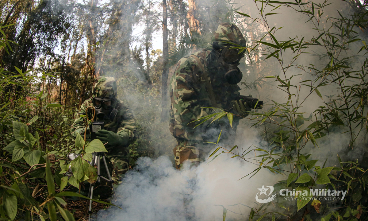 Two soldiers assigned to a mobile detachment under the People's Armed Police (PAP) Force Yunnan Corps use detection devices to test the hazardous chemicals among the bushes in the anti-chemical emergency rescue training on January 18, 2022. (eng.chinamil.com.cn/Photo by Zheng Xiangquan) 