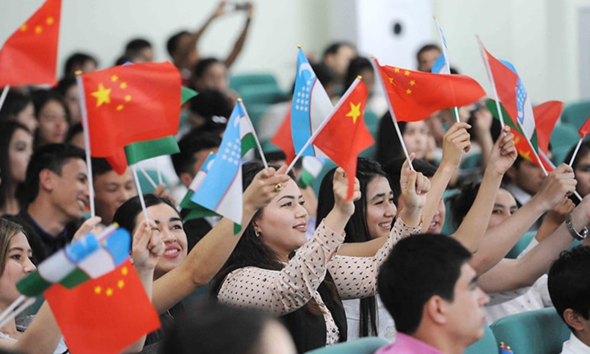 Students in Tashkent wave Chinese and Uzbek national flags during a Chinese language competition. Photo: Courtesy of Uzbek Embassy in China 