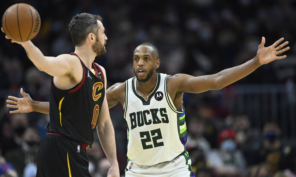Jan 26, 2022; Cleveland, Ohio, USA; Milwaukee Bucks forward Khris Middleton (22) defends Cleveland Cavaliers forward Kevin Love (0) in the third quarter at Rocket Mortgage FieldHouse. Mandatory Credit: David Richard-USA TODAY Sports