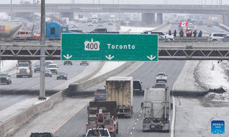 People gather on a bridge over Highway 400 in support of truckers, who are on their way to Ottawa for the freedom convoy protest, in Vaughan, Ontario, Canada, on Jan. 27, 2022. The freedom convoy was sparked by outrage over a vaccine mandate recently imposed on Canadian-U.S. cross-border truckers.(Photo: Xinhua)