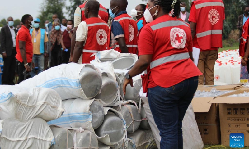 Uganda Red Cross officials distribute relief items to people affected by floods in Nyarusiza village, Kisoro District, Uganda, on Jan. 26, 2022. Torrential rains, floods and a mudslide have affected 800 people in three sub-counties in the western Ugandan district of Kisoro, a relief agency said on Thursday.(Photo: Xinhua)