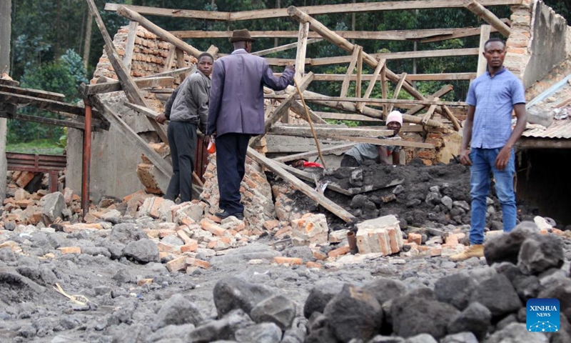 People gather at their houses damaged by floods in Nyarusiza village, Kisoro District, Uganda, on Jan. 26, 2022. Torrential rains, floods and a mudslide have affected 800 people in three sub-counties in the western Ugandan district of Kisoro, a relief agency said on Thursday.(Photo: Xinhua)
