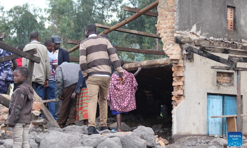 People gather at their houses damaged by floods in Nyarusiza village, Kisoro District, Uganda, on Jan. 26, 2022. Torrential rains, floods and a mudslide have affected 800 people in three sub-counties in the western Ugandan district of Kisoro, a relief agency said on Thursday.(Photo: Xinhua)