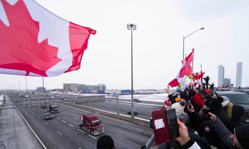 People gather on a bridge over Highway 400 in support of truckers, who are on their way to Ottawa for the freedom convoy protest, in Vaughan, Ontario, Canada, on Jan. 27, 2022. The freedom convoy was sparked by outrage over a vaccine mandate recently imposed on Canadian-U.S. cross-border truckers.(Photo: Xinhua)