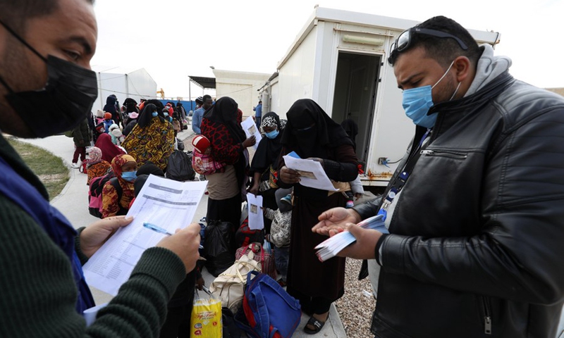 Officials of the International Organization for Migration (IOM) distribute boarding tickets to the illegal migrants at the Misurata International Airport in Misurata, Libya, Jan. 27, 2022.(Photo: Xinhua)