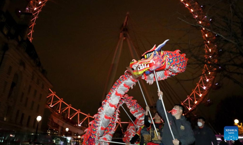 Traditional Chinese lion dancers perform in front of the London Eye which is lit up in red to celebrate the upcoming Chinese New Year in London, Britain, on Jan. 28, 2022.Photo:Xinhua