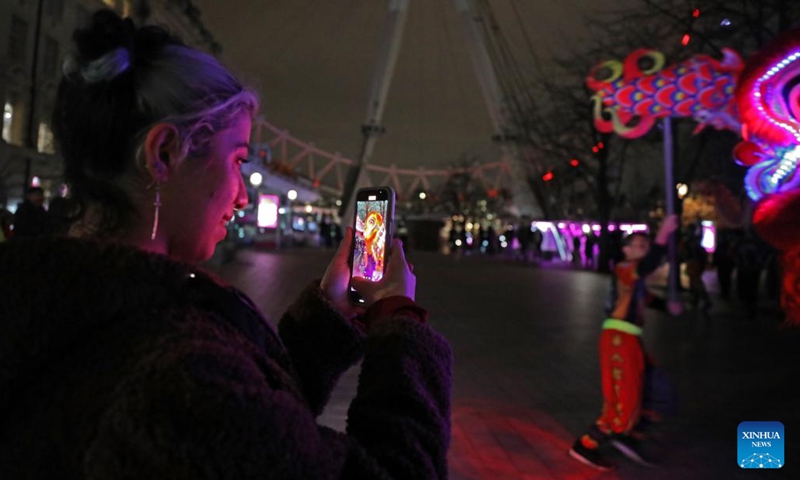 Traditional Chinese lion dancers perform in front of the London Eye which is lit up in red to celebrate the upcoming Chinese New Year in London, Britain, on Jan. 28, 2022.Photo:Xinhua