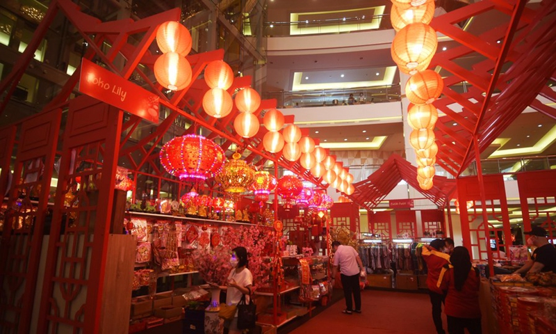 People walk under red lanterns set for the upcoming Chinese Lunar New Year at a shopping mall in Jakarta, Indonesia, Jan. 26, 2022. (Photo: Xinhua)