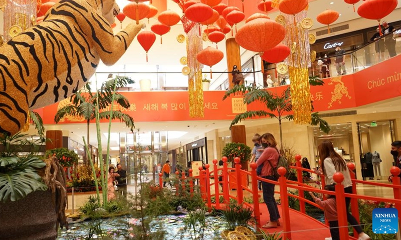 People are seen in front of tiger-themed decorations in South Coast Plaza, Orange County of California, the United States, on Jan. 27, 2022.Photo:Xinhua