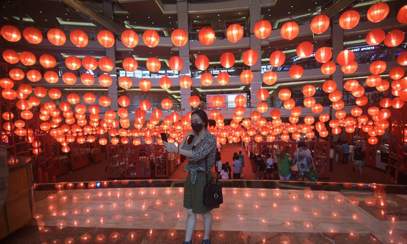 A woman takes photos of red lanterns set for the upcoming Chinse Lunar New Year at a shopping mall in Jakarta, Indonesia, Jan. 26, 2022. (Photo: Xinhua)