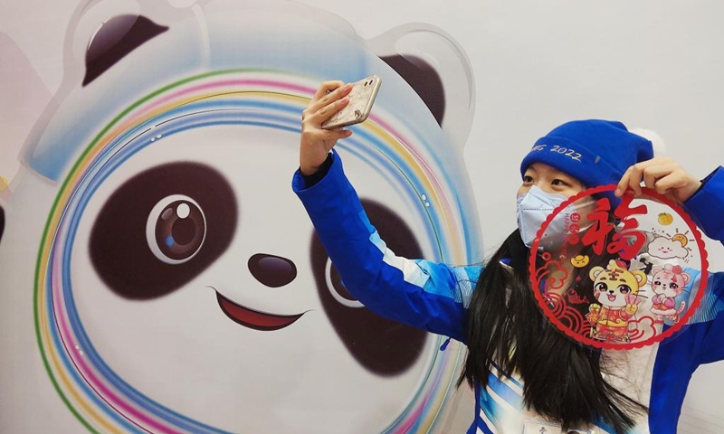 A volunteer poses for selfies at the Olympic Village for the Beijing 2022 Winter Olympics in Yanqing District of Beijing, capital of China, Jan. 31, 2022. Delegation members and volunteers celebrated the Chinese Lunar New Year, or the Year of Tiger at the Olympic Village on Monday. (Photo by Luo Minli/Xinhua)